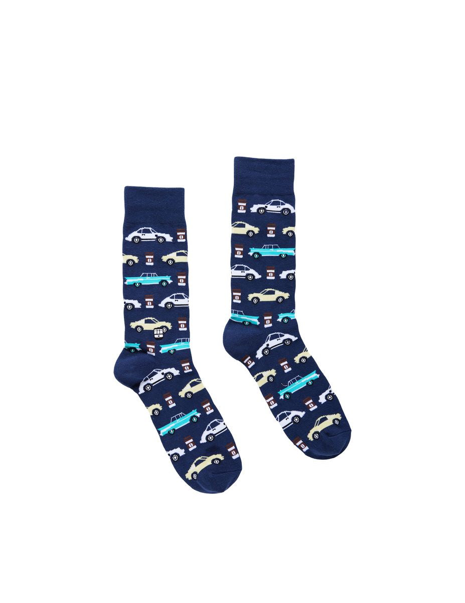Textile design pair of navy blue crew socks showcasing a repeating pattern of vintage turquoise, cream, and white cars alongside small red and white gas pump icons on a solid white background