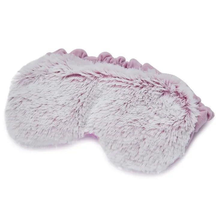 Studio photograph of a plush sleep mask on a white background featuring a soft lavender ruffled border and a textured white and light purple variegated faux fur surface