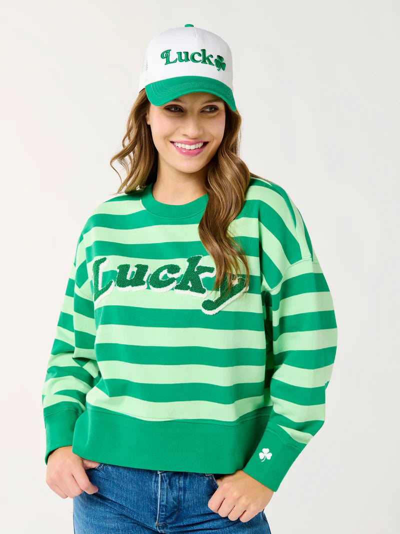 Digital photograph of a smiling woman in a studio wearing a St. Patrick&