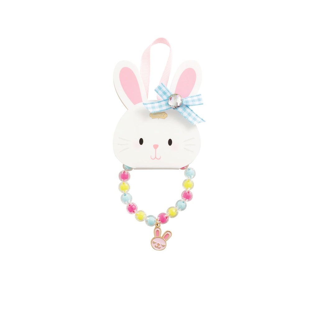 Children's jewelry accessory by Mud Pie featuring a colorful beaded bracelet with a pink rabbit charm displayed on a white bunny-shaped card decorated with a blue gingham bow and a sparkling rhinestone centerpiece against a white backdrop