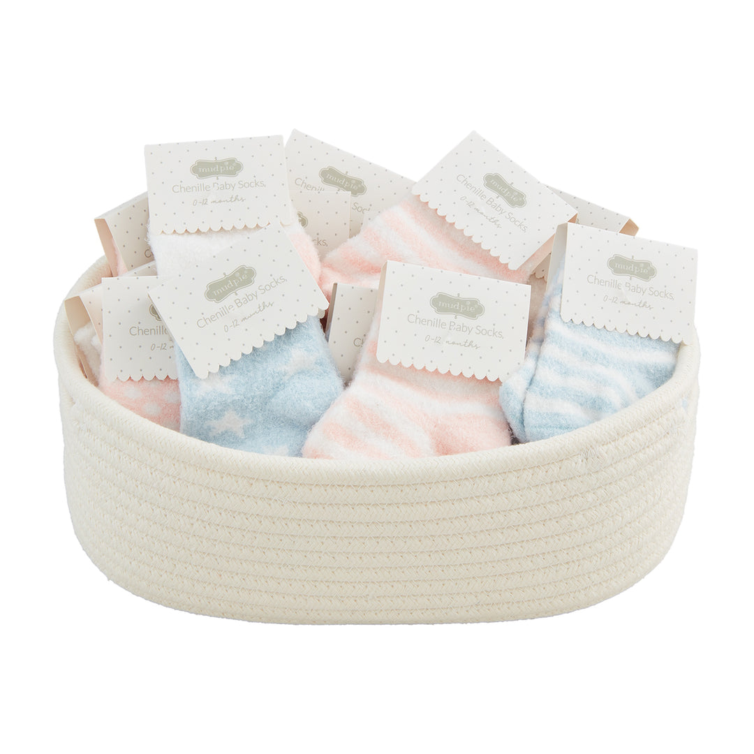 Rope basket filled with pink and blue chenille baby socks on cards