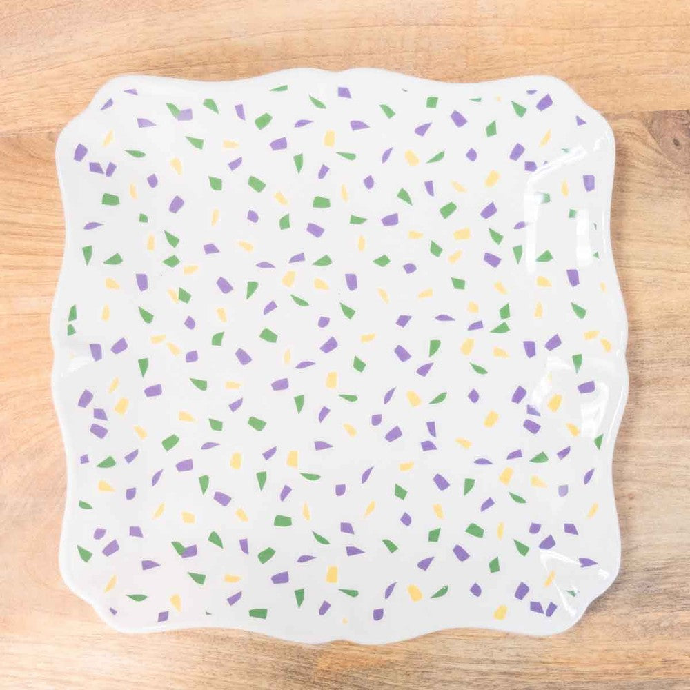 White scalloped square platter with purple, green and yellow confetti pattern on a wood table
