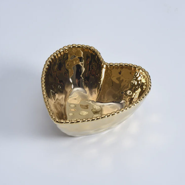 Gold-plated ceramic heart-shaped bowl on a white studio background featuring a beaded rim and a reflective hammered metallic interior