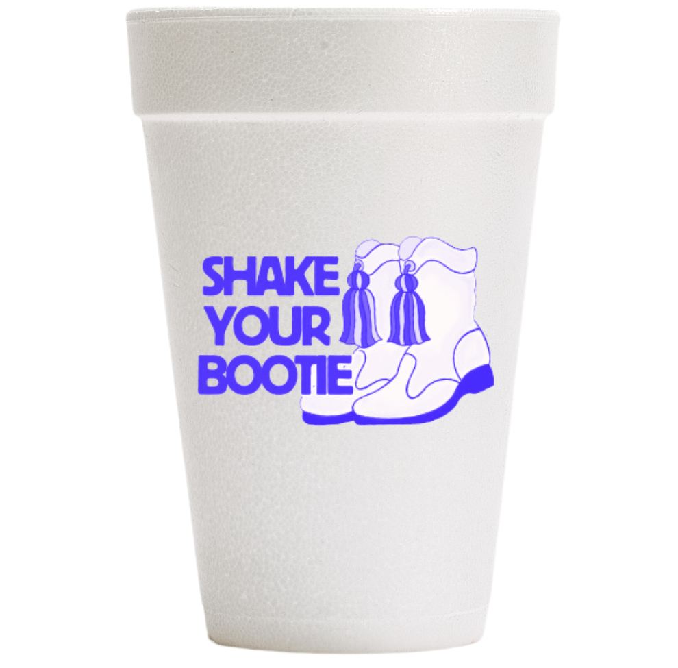 Digital photograph of a custom-printed white Styrofoam cup centered against a white background featuring the bold purple text SHAKE YOUR BOOTIE alongside an illustration of white boots with purple tassels and thick purple soles