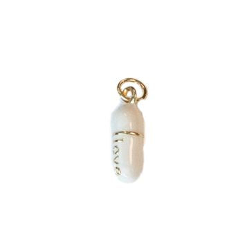 Enamel and gold-tone jewelry charm of a white pill capsule isolated on a white background featuring vertical gold script spelling love and a central gold band with a small jump ring for attachment