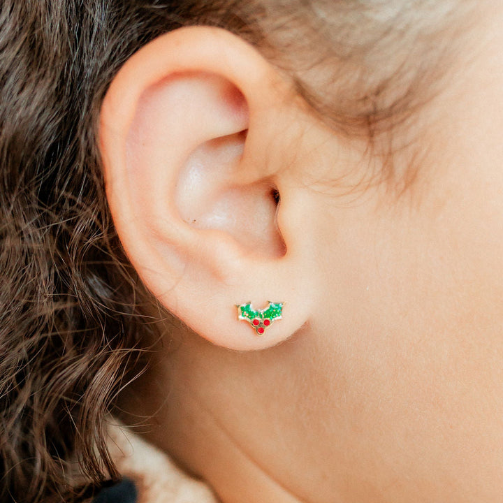 Photograph of a festive holly earring on a child&