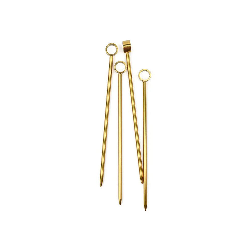 Four gold cocktail picks with ring tops