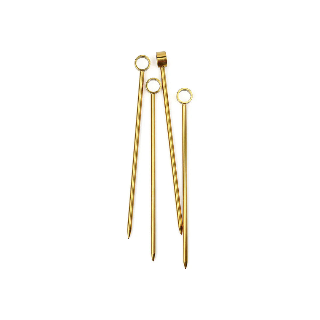 Four gold cocktail picks with ring tops