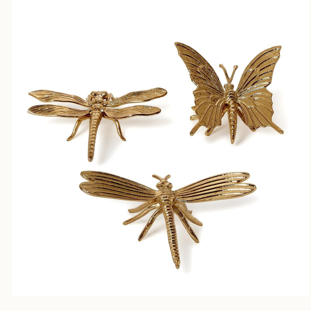 Gold-finished metal sculptures of one butterfly and two dragonflies set against a plain white background featuring intricate linear wing textures, segmented abdomens, and slender legs