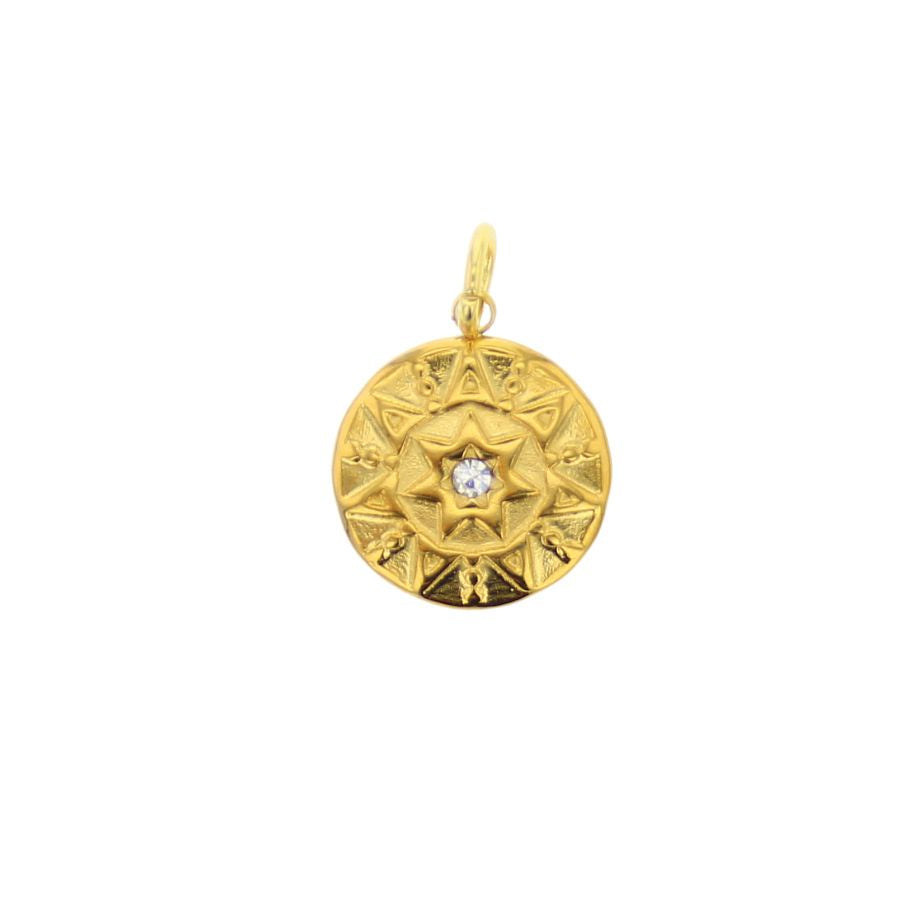 Gold jewelry pendant showcasing a central eight-pointed star set with a small clear gemstone and intricate radial geometric carvings against a minimalist white background