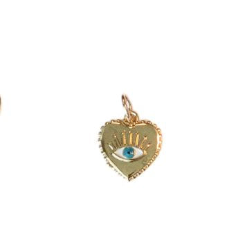 Gold jewelry pendant of a heart-shaped charm on a plain white background featuring a vibrant turquoise blue evil eye center with radiating golden eyelashes and a delicate beaded outer rim