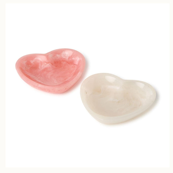 Handcrafted resin heart-shaped trinket dishes on a white background featuring swirling marble patterns in translucent pink and cream with a smooth polished finish