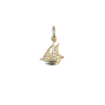 Gold jewelry charm featuring a miniature sailboat with sparkling stone-encrusted sails and a polished yellow-gold hull centered on a white background