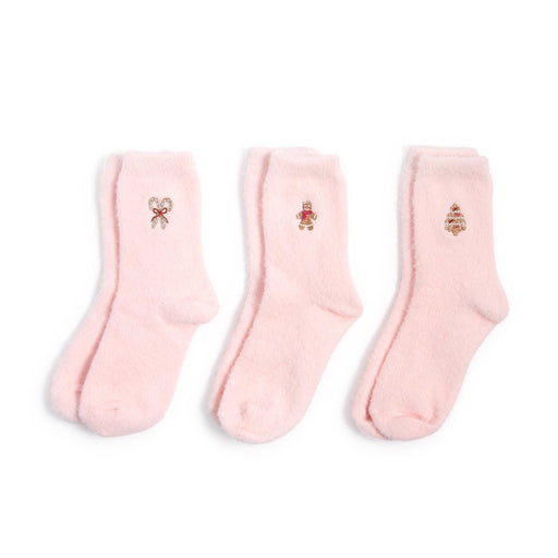 Studio product photograph of three pairs of light pink fuzzy socks on a white background featuring embroidered holiday motifs of a candy cane with a red bow, a gingerbread man, and a decorated Christmas tree