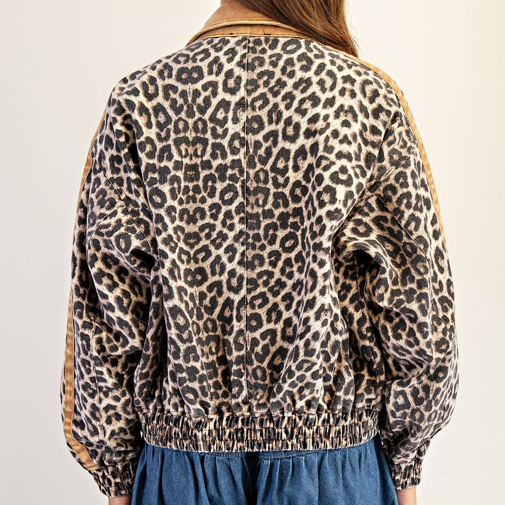 Digital photograph of a leopard print denim jacket featuring a tan corduroy collar, an elasticated waistband, and brown sleeve stripes against a neutral studio background