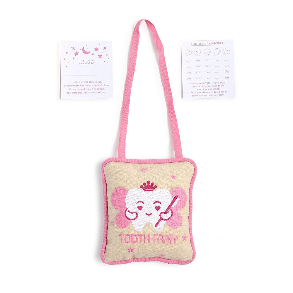 Commercial product photography of a beige canvas tooth fairy pillow kit on a white background featuring a pink embroidered winged tooth wearing a crown alongside paper cards decorated with pink stars and moons