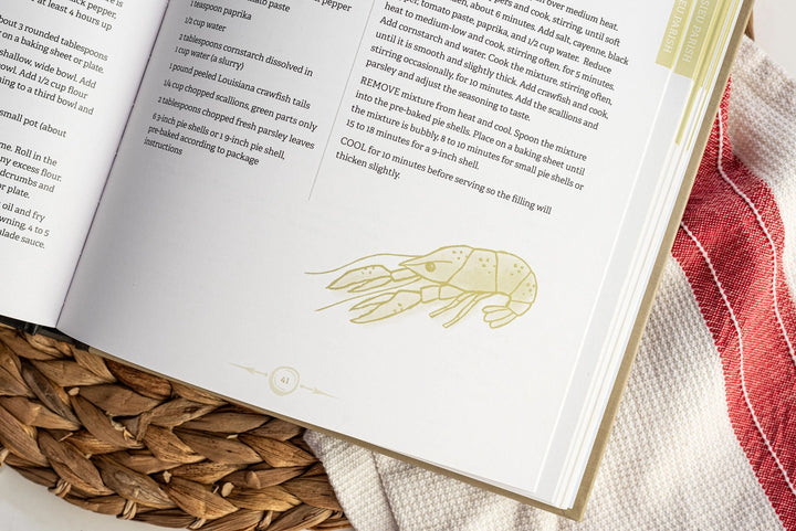 Printed cookbook page featuring a Louisiana crawfish recipe with a green line-art crawfish illustration, page number 41, and a red and white checkered cloth over a woven wicker basket