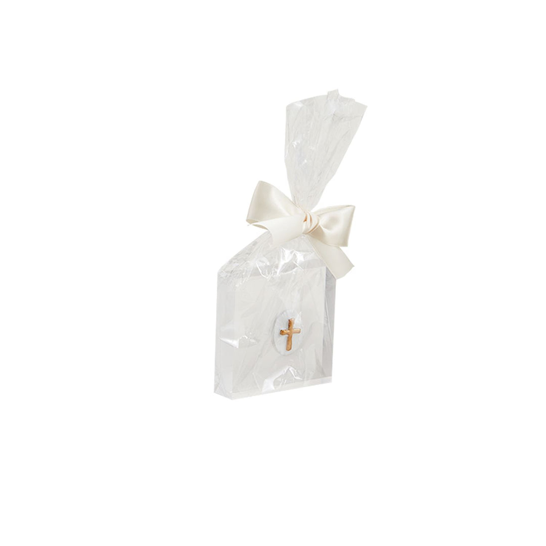 Product photograph of a religious souvenir gift favor presented on a white background featuring a package wrapped in crinkled clear cellophane tied with a cream satin bow and embellished with a miniature golden cross emblem