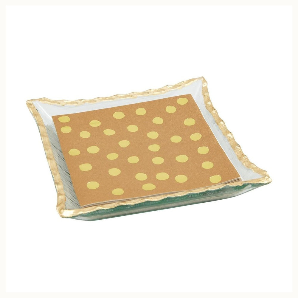 Hand-sculpted clear glass tray with a textured gold-leafed wavy rim holding a stack of brown napkins with yellow polka dots on a plain white background