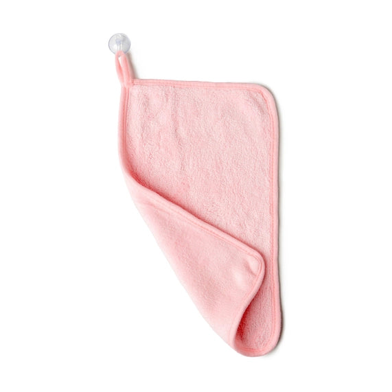 Studio photograph of a plush pink microfibre washcloth hanging from a clear suction cup hook against a plain white background, showcasing its soft fuzzy texture and rounded stitched corner