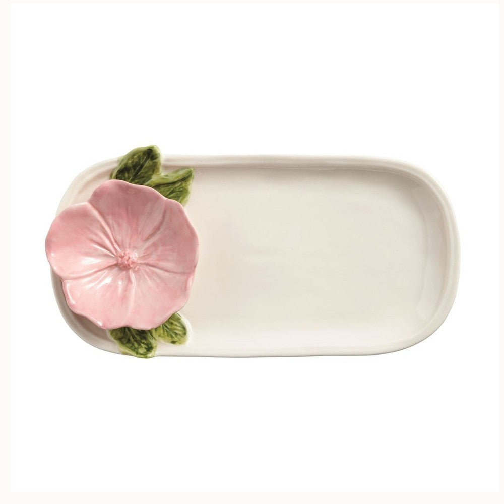 Majolica ceramic tray by Bordallo Pinheiro featuring a hand-painted pink blossom with detailed green leaves on an off-white elongated platter against a white background