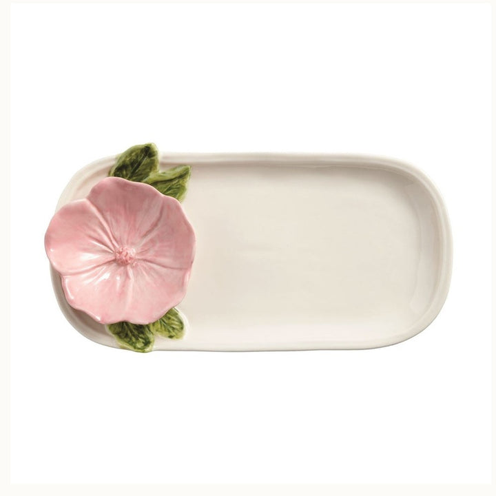 Majolica ceramic tray by Bordallo Pinheiro featuring a hand-painted pink blossom with detailed green leaves on an off-white elongated platter against a white background