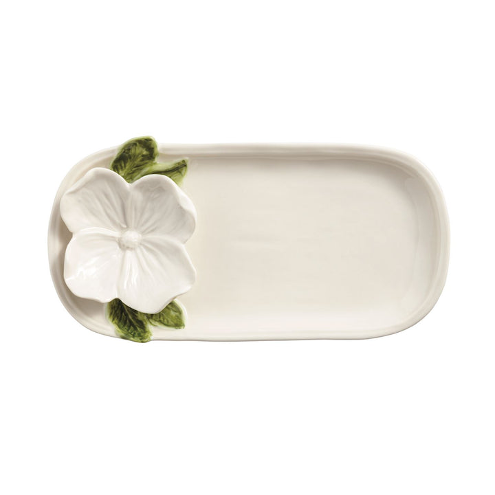 Ceramic platter by Vietri featuring a sculpted white hibiscus flower on a small rectangular tray with vibrant green leaves and a glossy cream finish