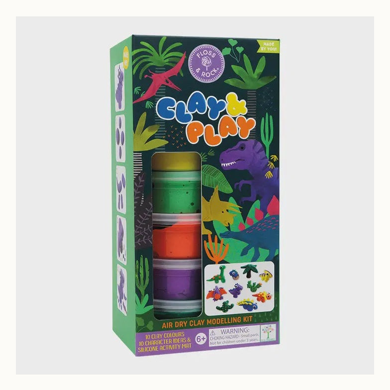 Packaging design by Floss & Rock for a dinosaur-themed air dry clay modelling kit set in a prehistoric jungle, featuring a purple Tyrannosaurus Rex, a pink Pterodactyl, and five stacked tubs of vibrant yellow, green, and orange clay alongside a display of small clay dinosaur models