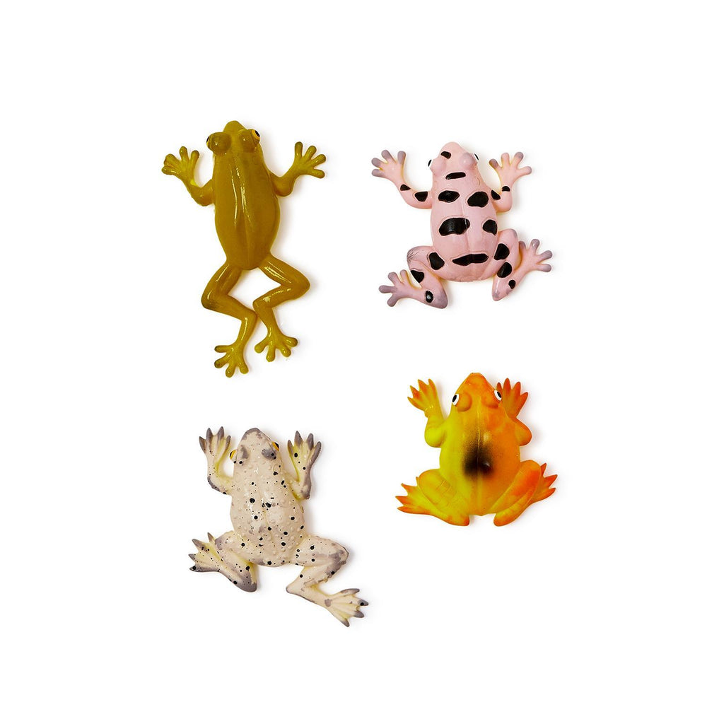 Plastic toy figurines of four colorful frogs on a white background featuring a translucent olive green frog, a pink frog with large black spots, and a yellow-orange frog with a dark dorsal smudge