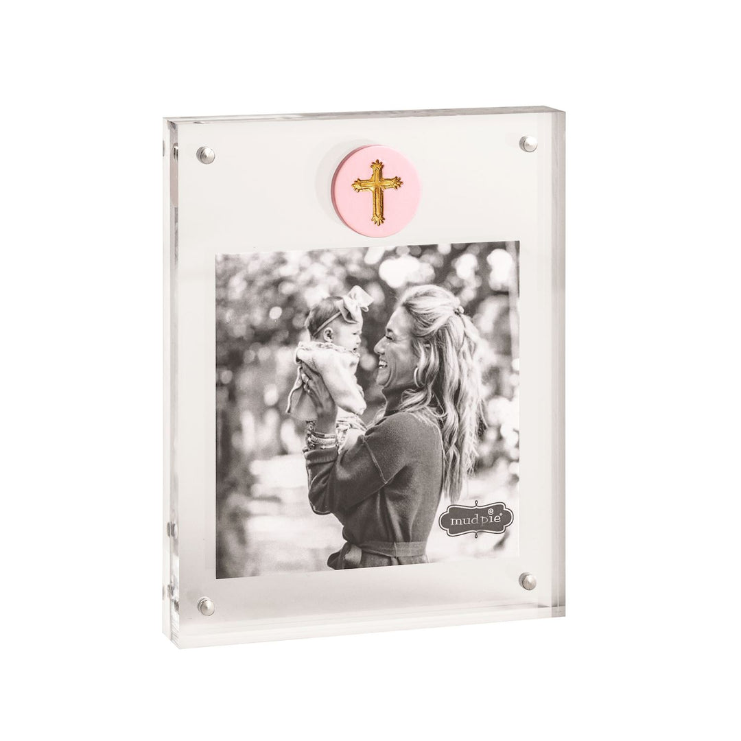 Acrylic magnetic picture frame by Mud Pie featuring a black and white photograph of a woman holding a baby in an outdoor garden setting with a pink ceramic medallion with a gold cross and silver magnetic corner fasteners