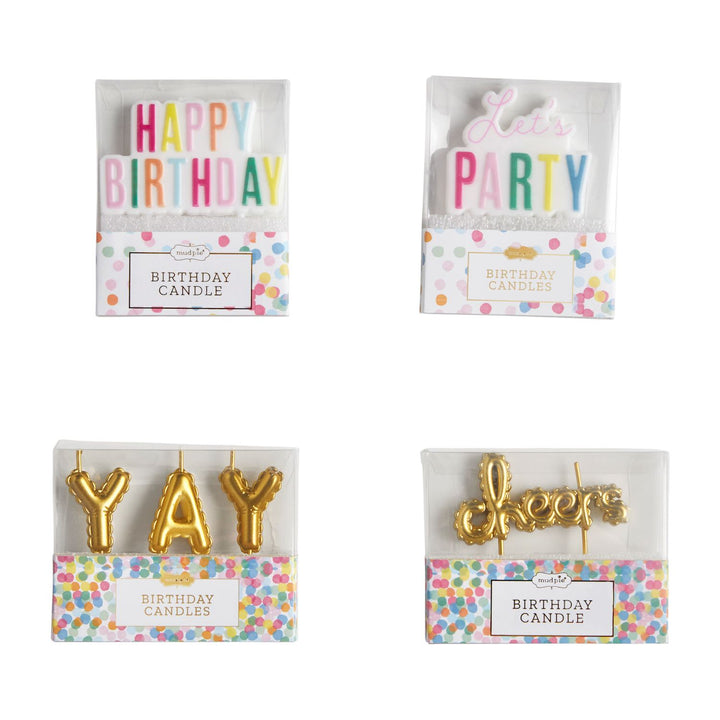 Product photograph by Mud Pie of four birthday candle sets in clear packaging against a white background featuring multi-colored block letters spelling Happy Birthday and Let&
