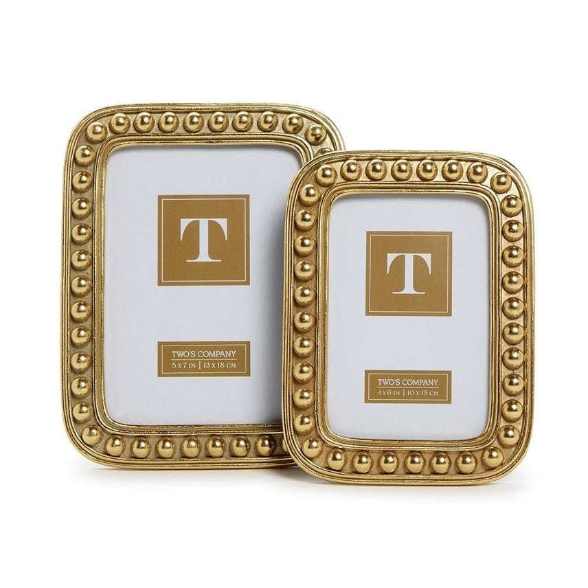 Gold metal frames by Two's Company featuring a textured bead border and rounded corners in two sizes with signature T logo inserts on a white background