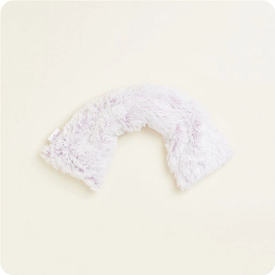 Product photograph of a plush, shaggy arch-shaped toy centered on a plain off-white background featuring soft lavender-tinted white faux fur and a small white fabric tag on the left side