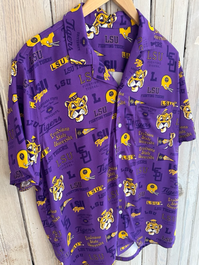 Purple LSU Tigers print button-up shirt hanging against a weathered wood fence