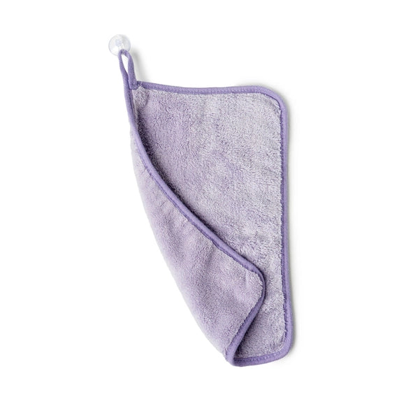 Studio photograph of a plush purple microfiber face cloth featuring a soft textured surface, a reinforced stitched border, and a hanging loop with a clear suction cup on a white background