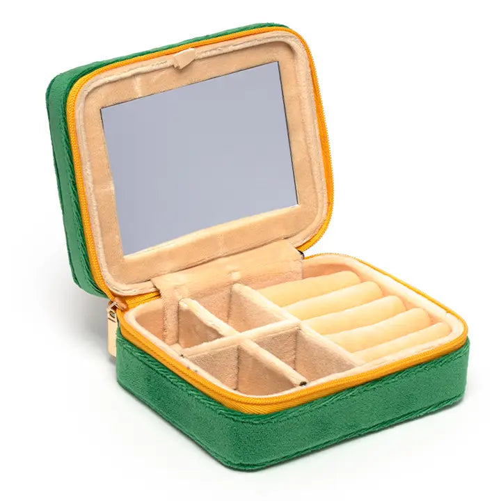 Green velvet travel jewelry box open on a white background featuring a built-in rectangular mirror, a vibrant yellow zipper, and plush beige ring storage compartments