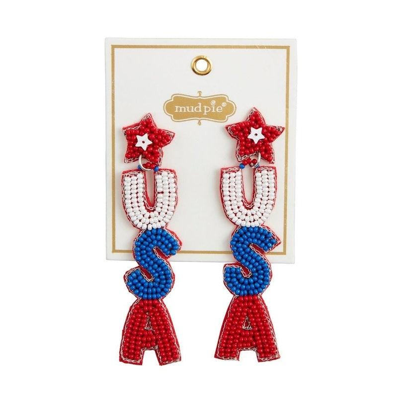 Beaded earrings by Mud Pie featuring a patriotic USA design on a white product card, showcasing red star-shaped studs with white center accents and vertically dangling letters in vibrant red, white, and blue seed beads