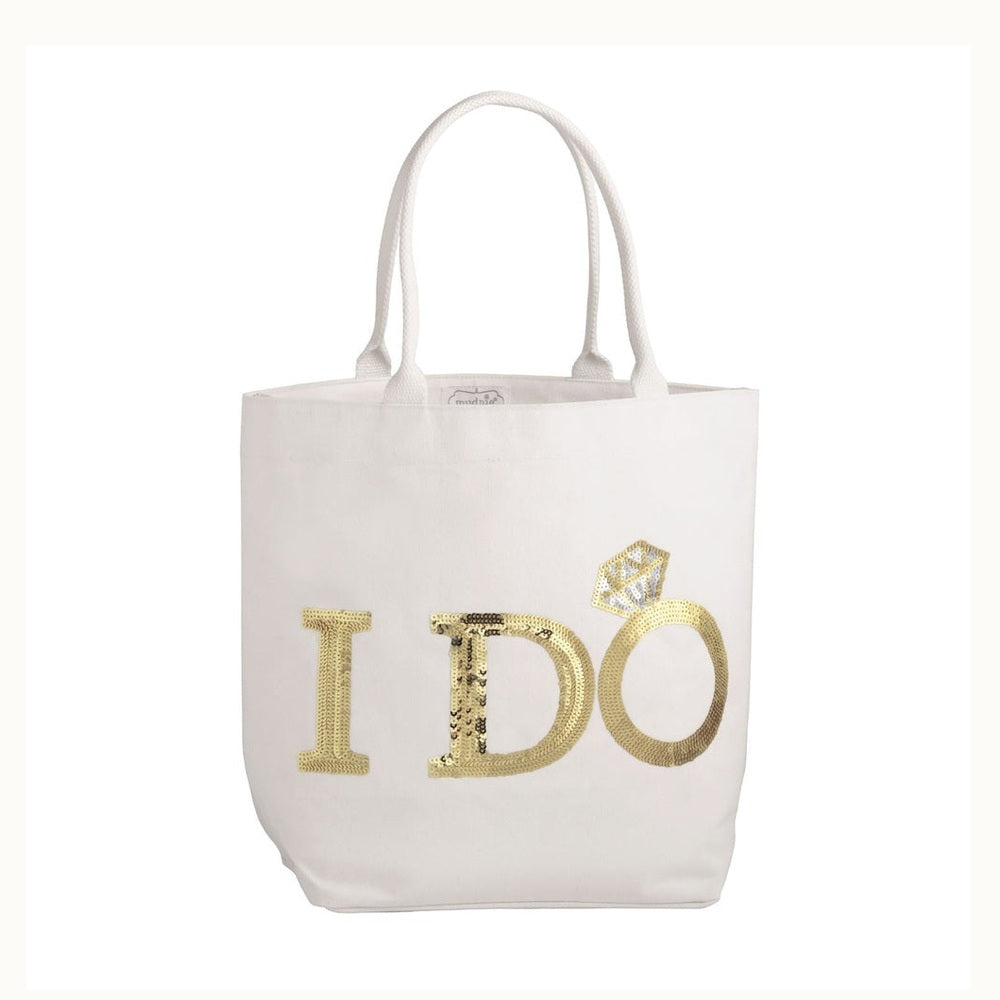 Mud Pie canvas tote bag featuring a bridal accessory against a white background with gold sequined I DO lettering and a sparkling silver sequin diamond ring embellishment
