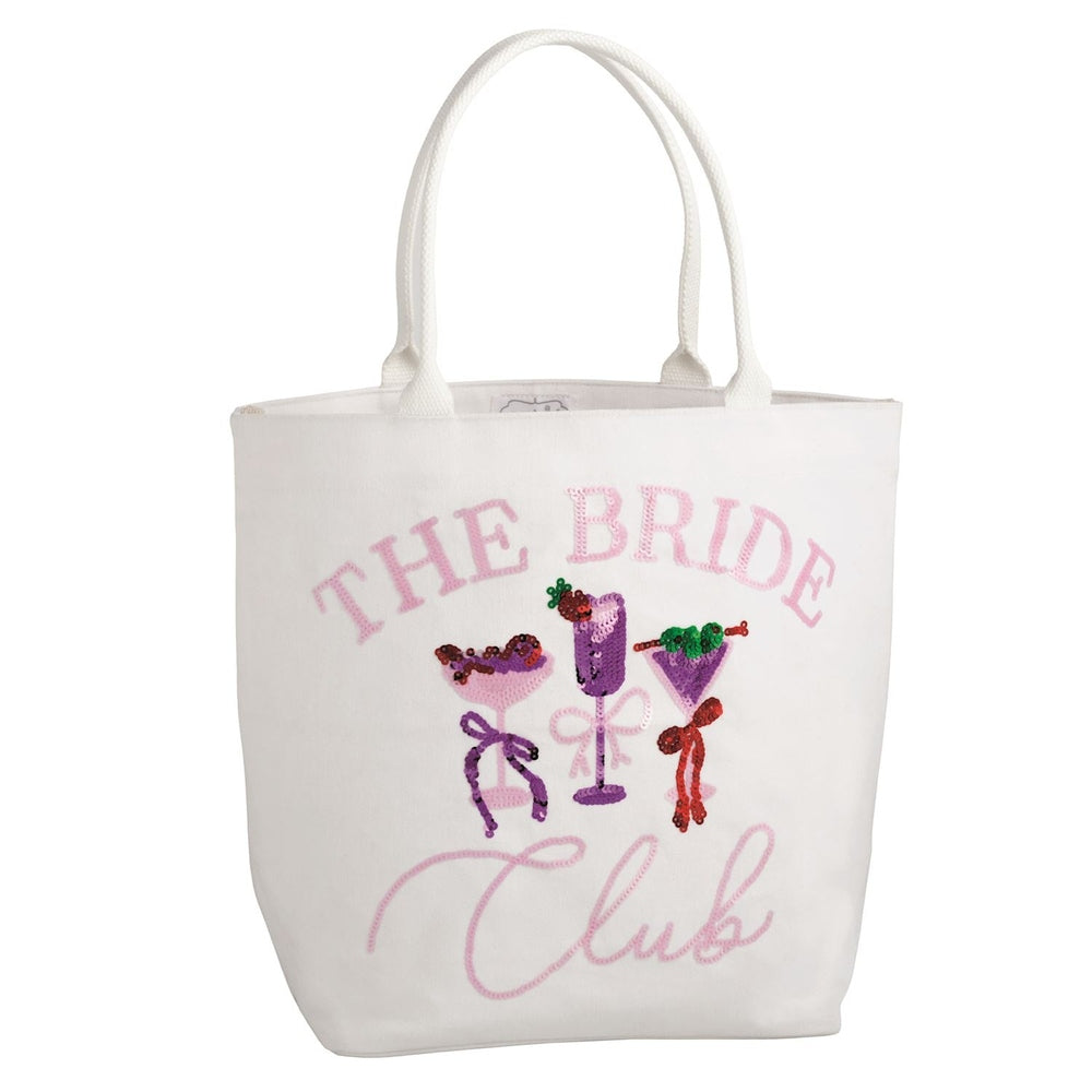 Mud Pie white canvas tote bag featuring THE BRIDE Club in pink embroidered lettering on a white background with three shimmering sequined cocktail glasses accented by decorative bows and colorful fruit garnishes
