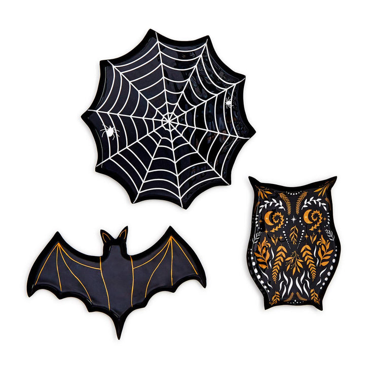 Three black Halloween plates shaped like a spiderweb, a bat and an owl with orange and white details