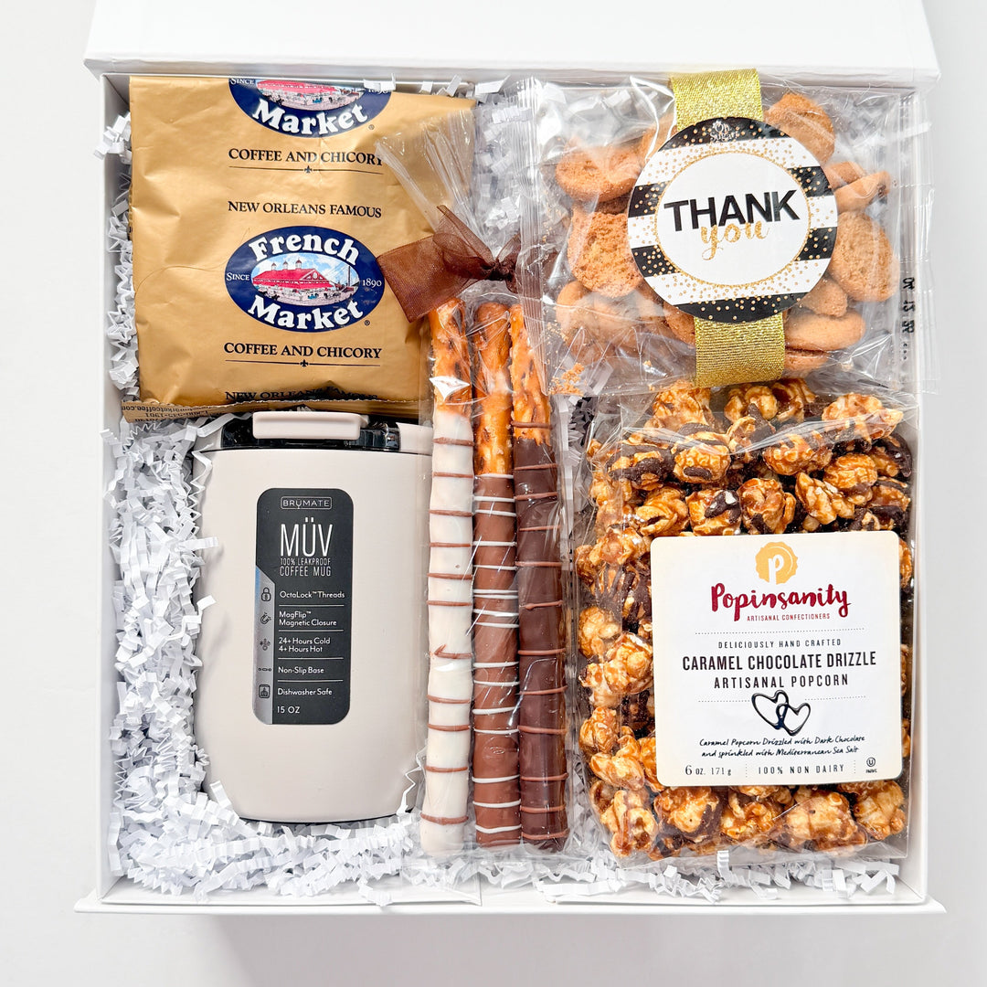 Gift box with snacks and a mug on a white background