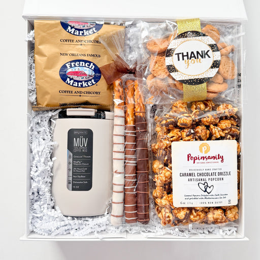 Gift box with snacks and a mug on a white background