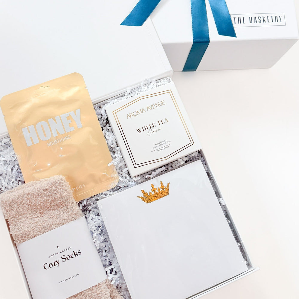Gift box of self care with cozy socks and relaxation items.
