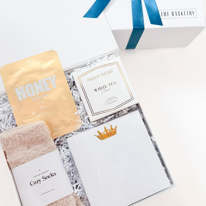 Gift box of self care with cozy socks and relaxation items.