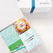 Gift set with a notebook, candy, and a box of chocolates in a white box with a blue ribbon.