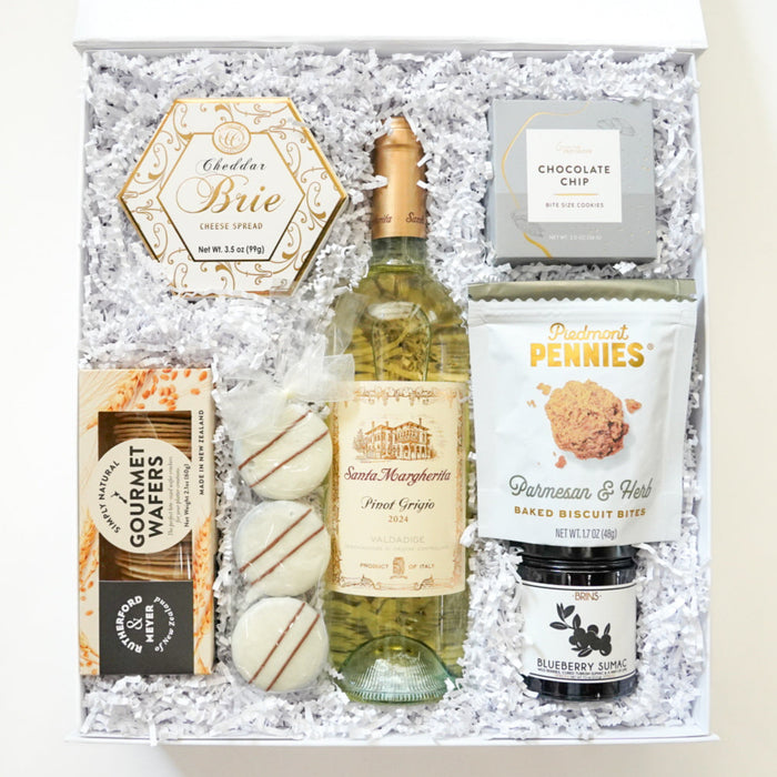 Gift basket with wine, snacks, and other items on a white background