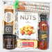Gift box with gourmet wafers, mixed nuts, chili fig spread, and barbecue sauce on a white background