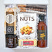 Gift basket with gourmet items including a bottle of butter, nuts, and spreads.