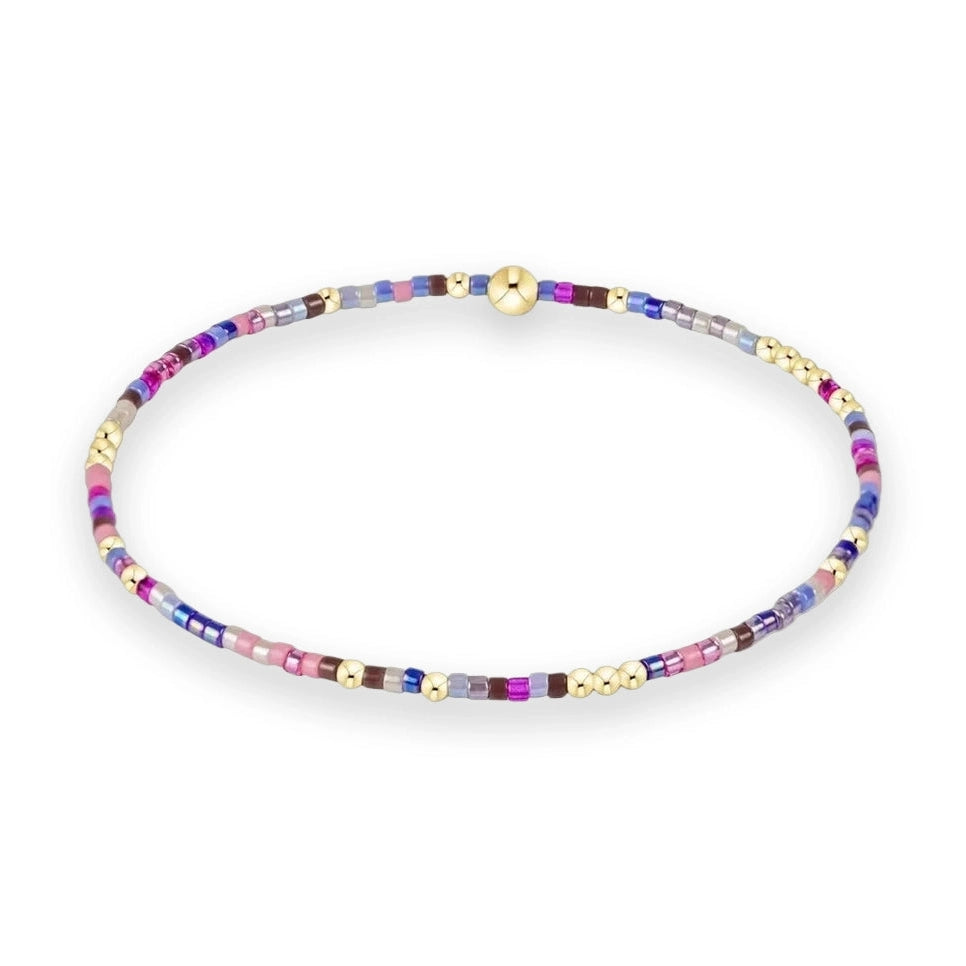 Beaded jewelry by enewton featuring a multicolored seed bead bracelet on a white background with a signature 14k gold-filled bead and vibrant magenta, lavender, and navy accents