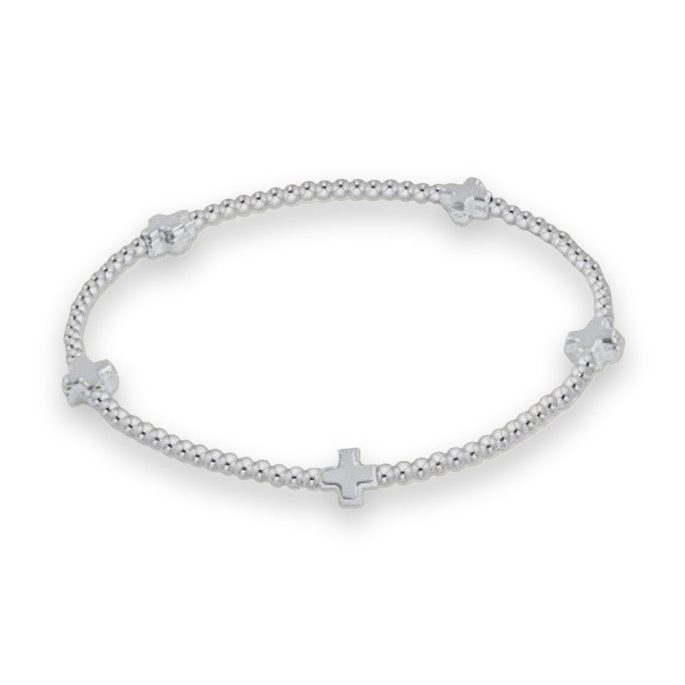 Silver beaded bracelet featuring a circular strand of polished metallic spheres punctuated by four equidistant Greek crosses on a minimalist neutral background
